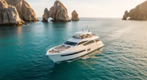 Luxury private yacht sailing in Cabo San Lucas with clear blue water and El Arco rock formation in the background