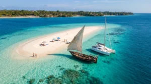 Aerial view of a white sandbank and traditional dhow sailboat in turquoise water, showcasing the best beaches in Zanzibar by boat